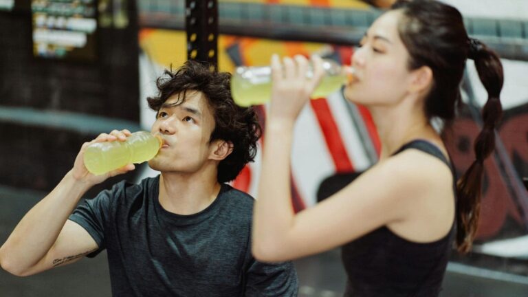 Two runners drinking electrolytes before run to optimise hydration and prepare for performance