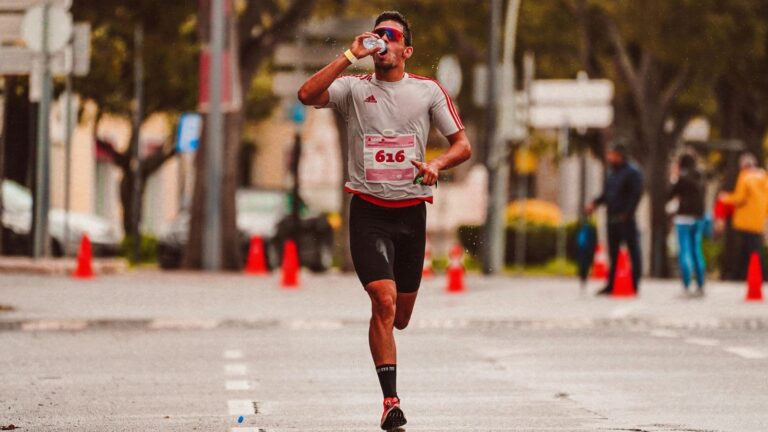 Runner drinking water during training run to maintain hydration and endurance performance