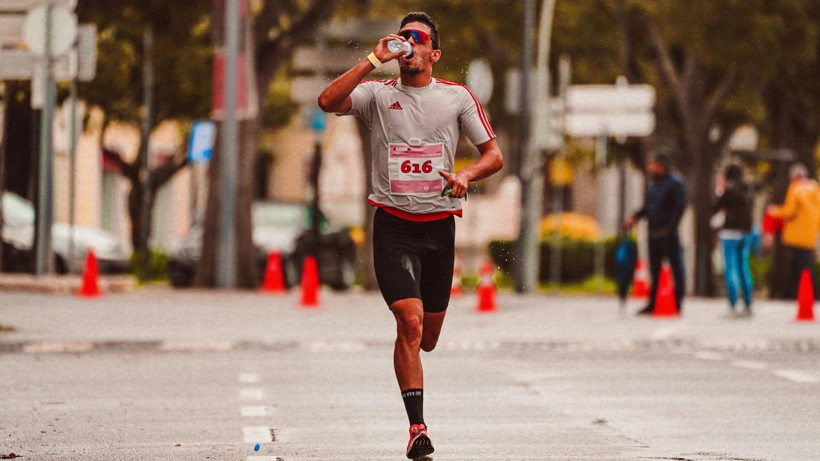 Runner drinking water during training run to maintain hydration and endurance performance