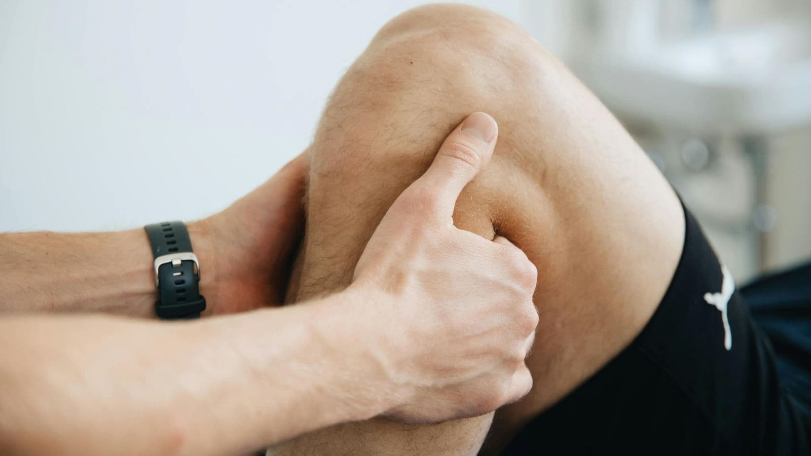 Runner with knee injury being assessed by professional, showing evaluation of runner’s knee condition