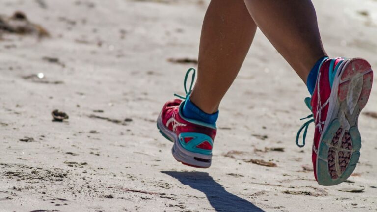 Close-up of a runner’s shoes in motion on the road, capturing the rhythm and intensity of running while emphasizing speed training.