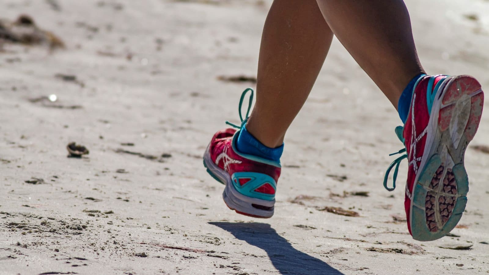 Close-up of a runner’s shoes in motion on the road, capturing the rhythm and intensity of running while emphasizing speed training.