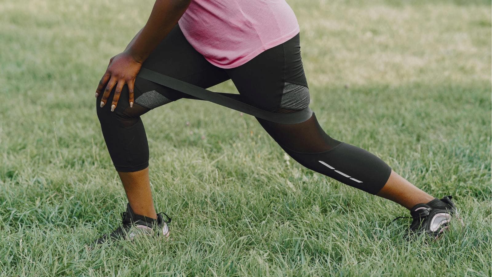 runner stretching iliotibial band to relieve pain caused by running injury
