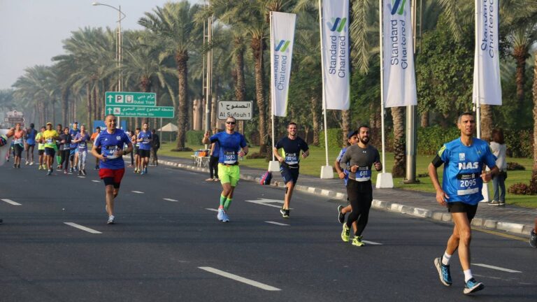 Group of runners racing on a road course, demonstrating stamina, pacing, and long-distance running endurance
