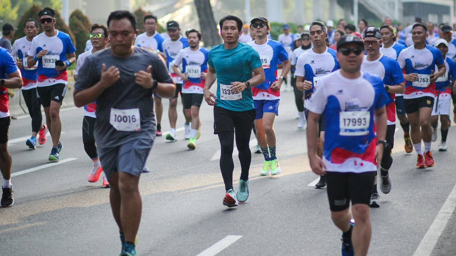 Runners competing in a long-distance race, maintaining pace and endurance during a marathon or road running event
