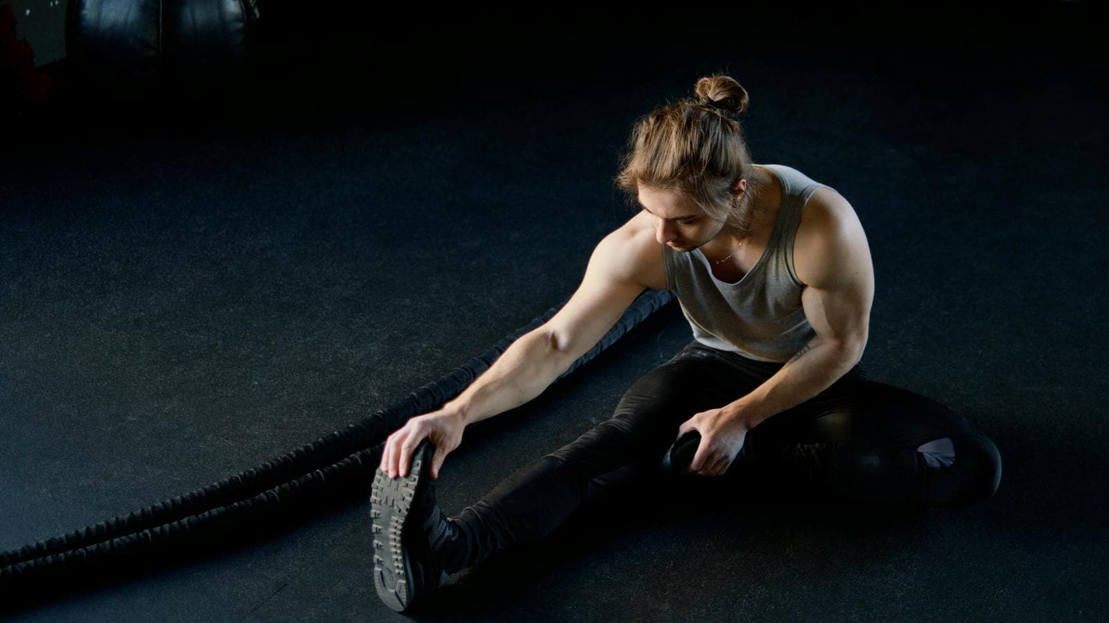 runner stretching iliotibial band and hip muscles to relieve pain caused by running injury