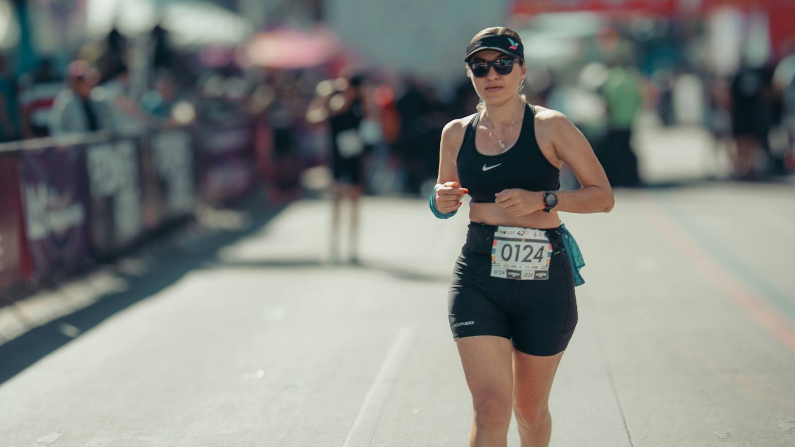 Runner maintaining steady pace during a marathon race on a city course
