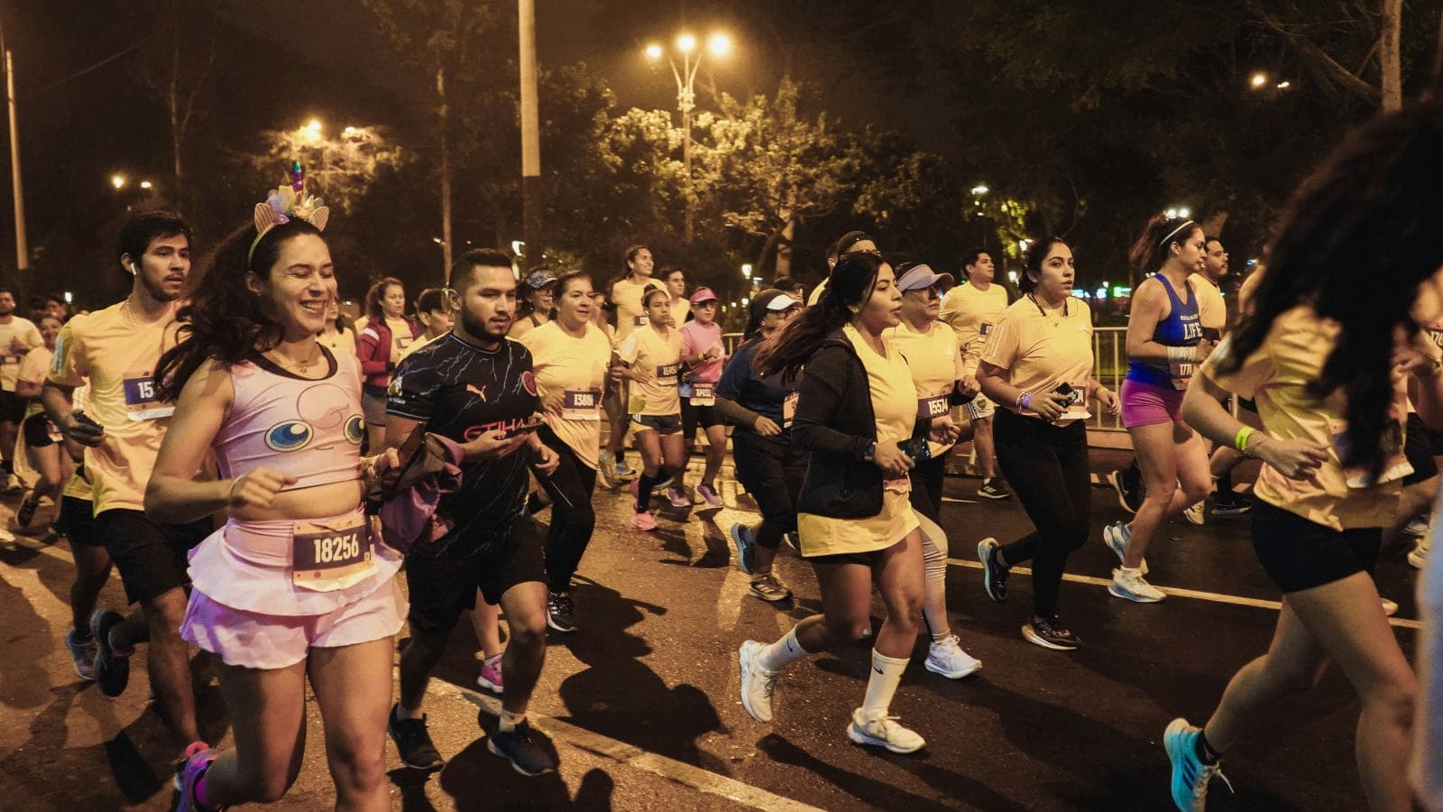 runner wearing reflective gear while running safely in the dark on a road at night