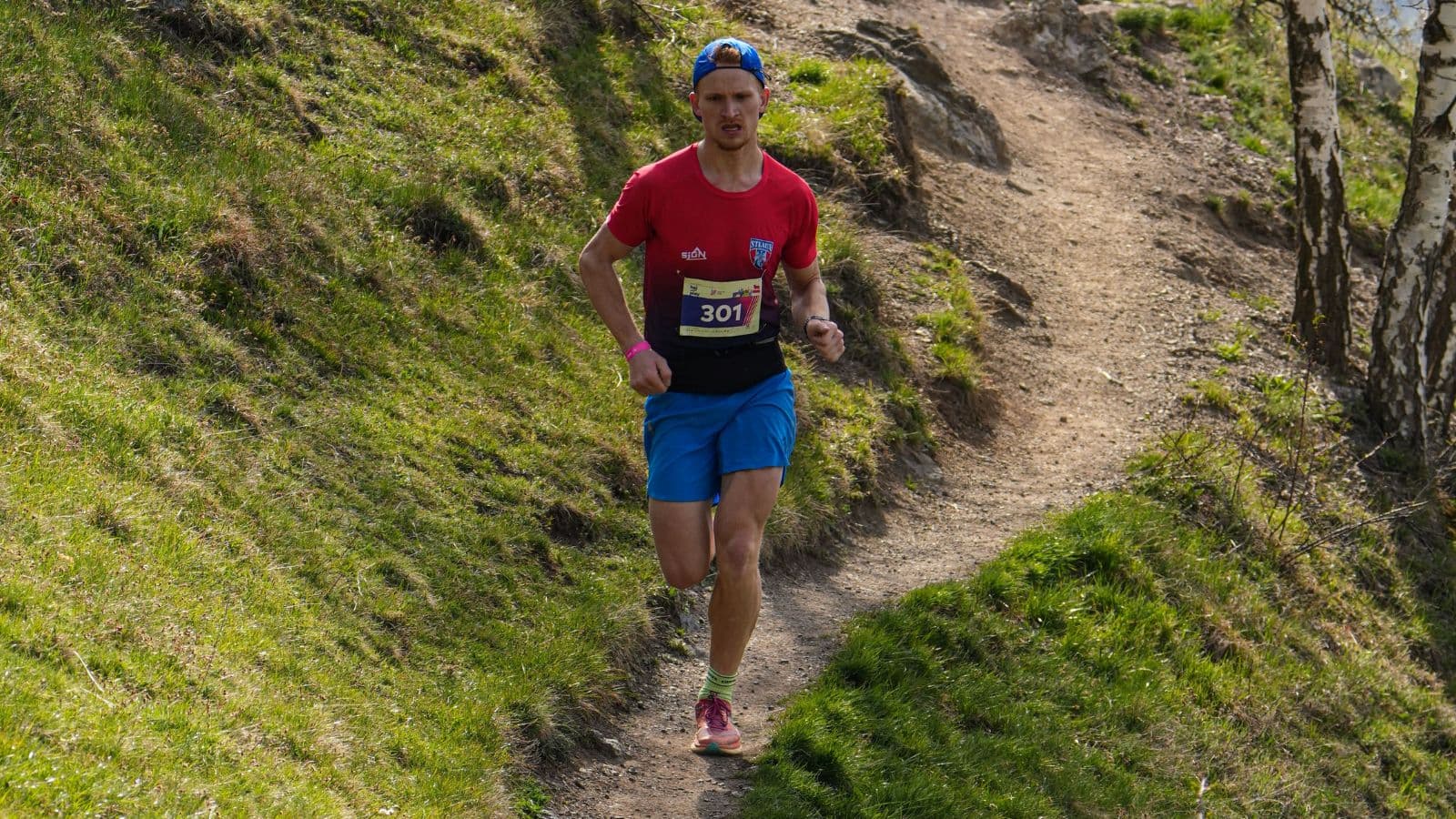 trail runner ascending rugged uphill terrain during elevation gain workout for improved fitness