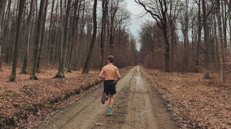 trail runner enjoying easy recovery run on forest trail as part of balanced training routine