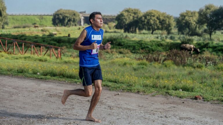 runner practicing barefoot running on grass while learning safe transition techniques