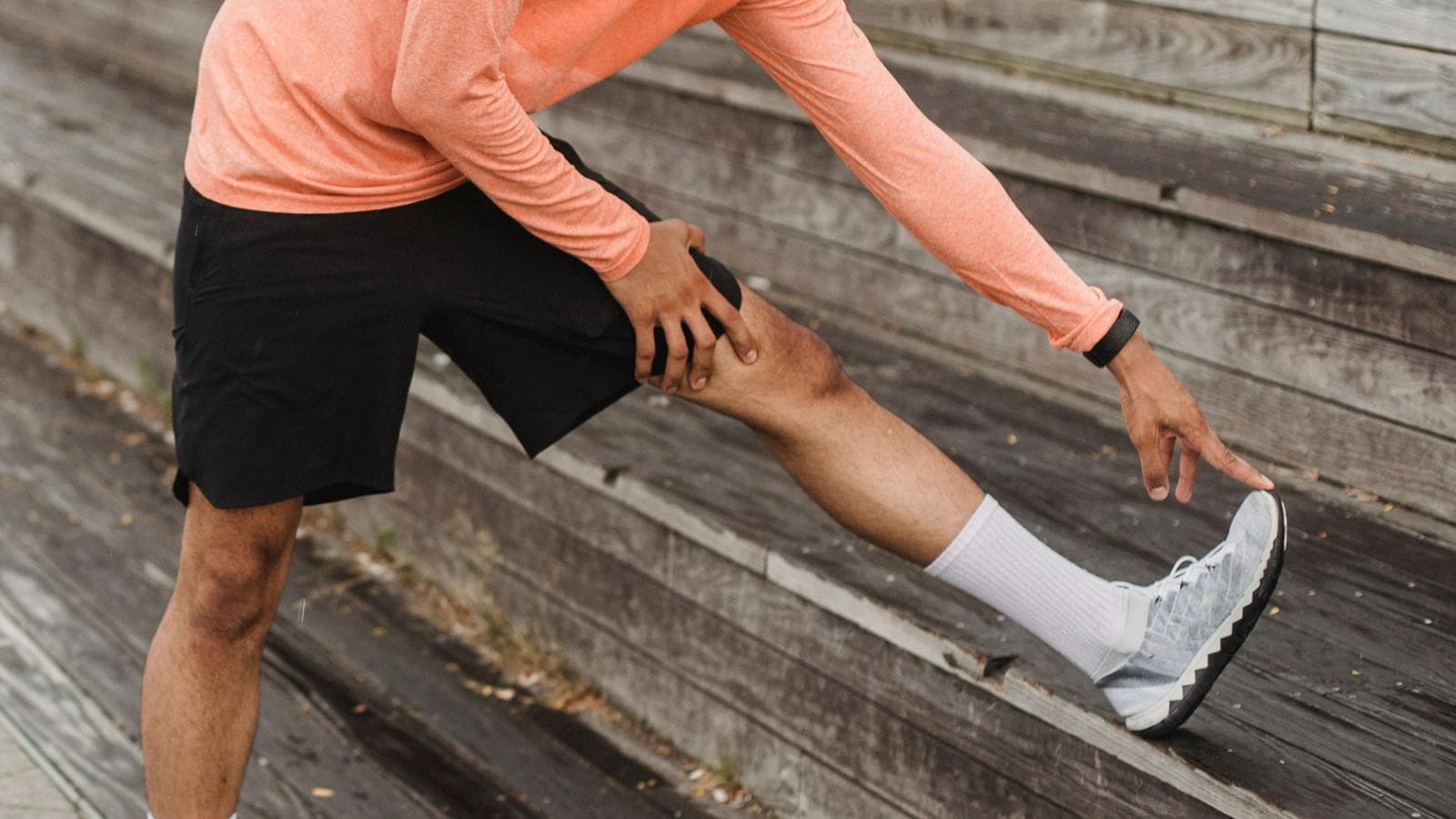 trail runner performing post run stretches after endurance workout on forest trail