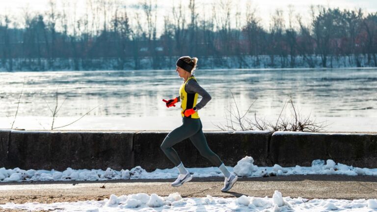 distance runner completing winter workout on snowy trail to improve endurance and running fitness