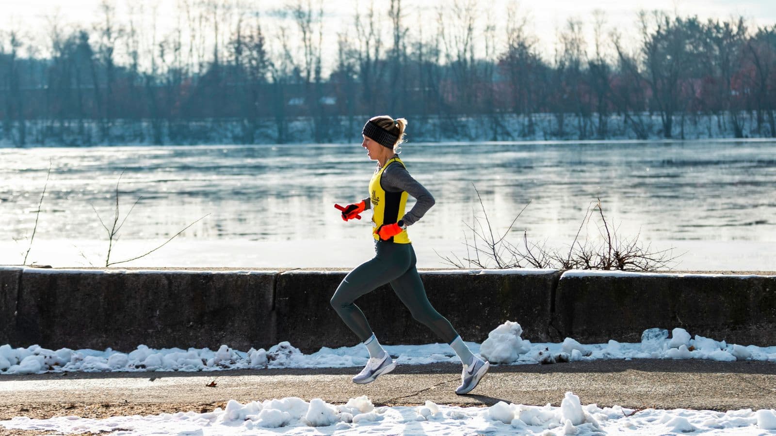 distance runner completing winter workout on snowy trail to improve endurance and running fitness