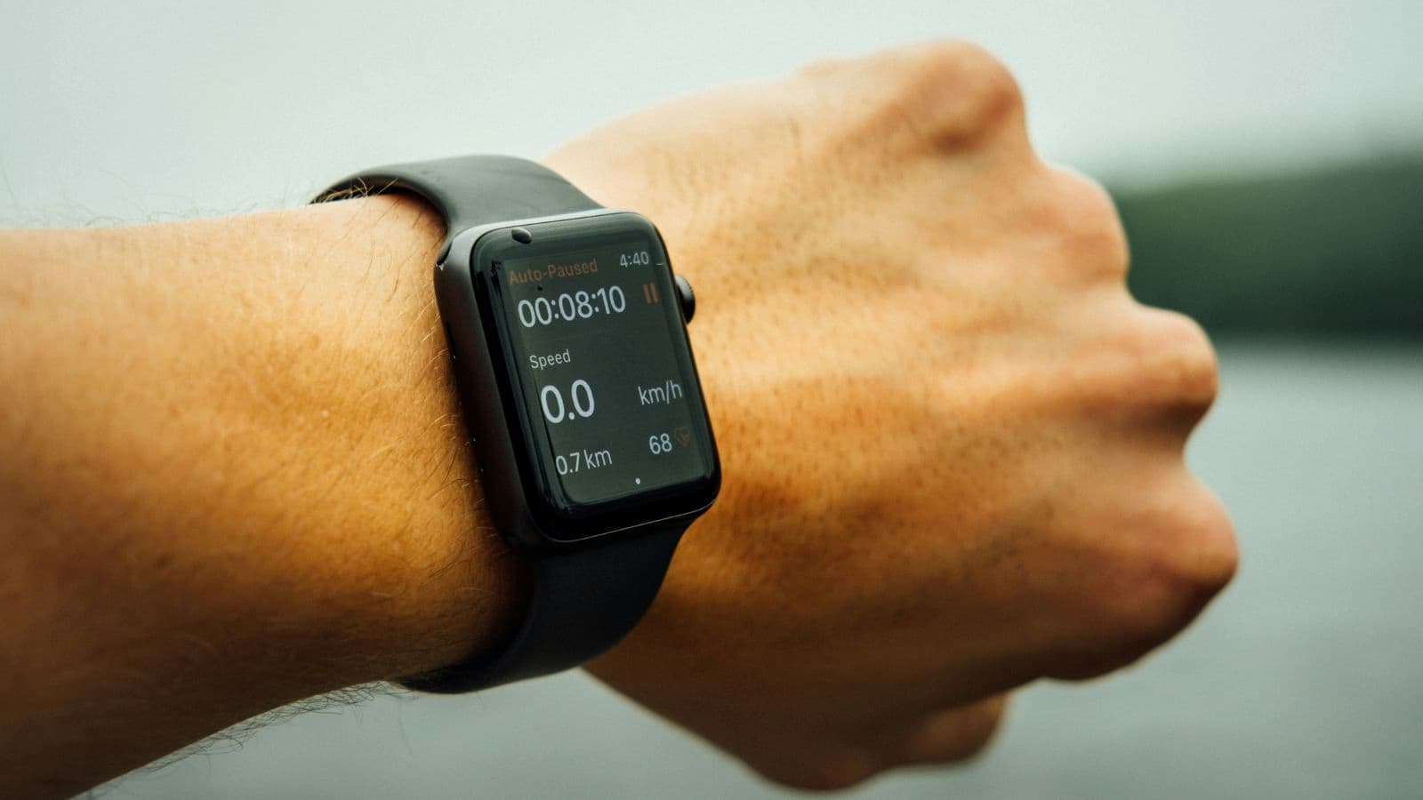 runner checking smartwatch data while learning not to rely solely on training metrics