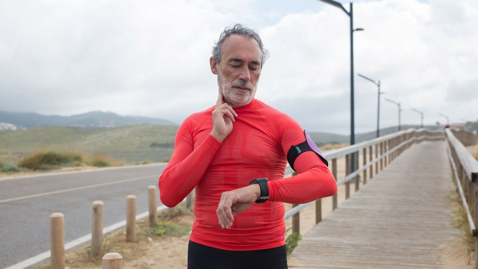 trail runner checking smartwatch data during trail run to monitor pace heart rate and elevation
