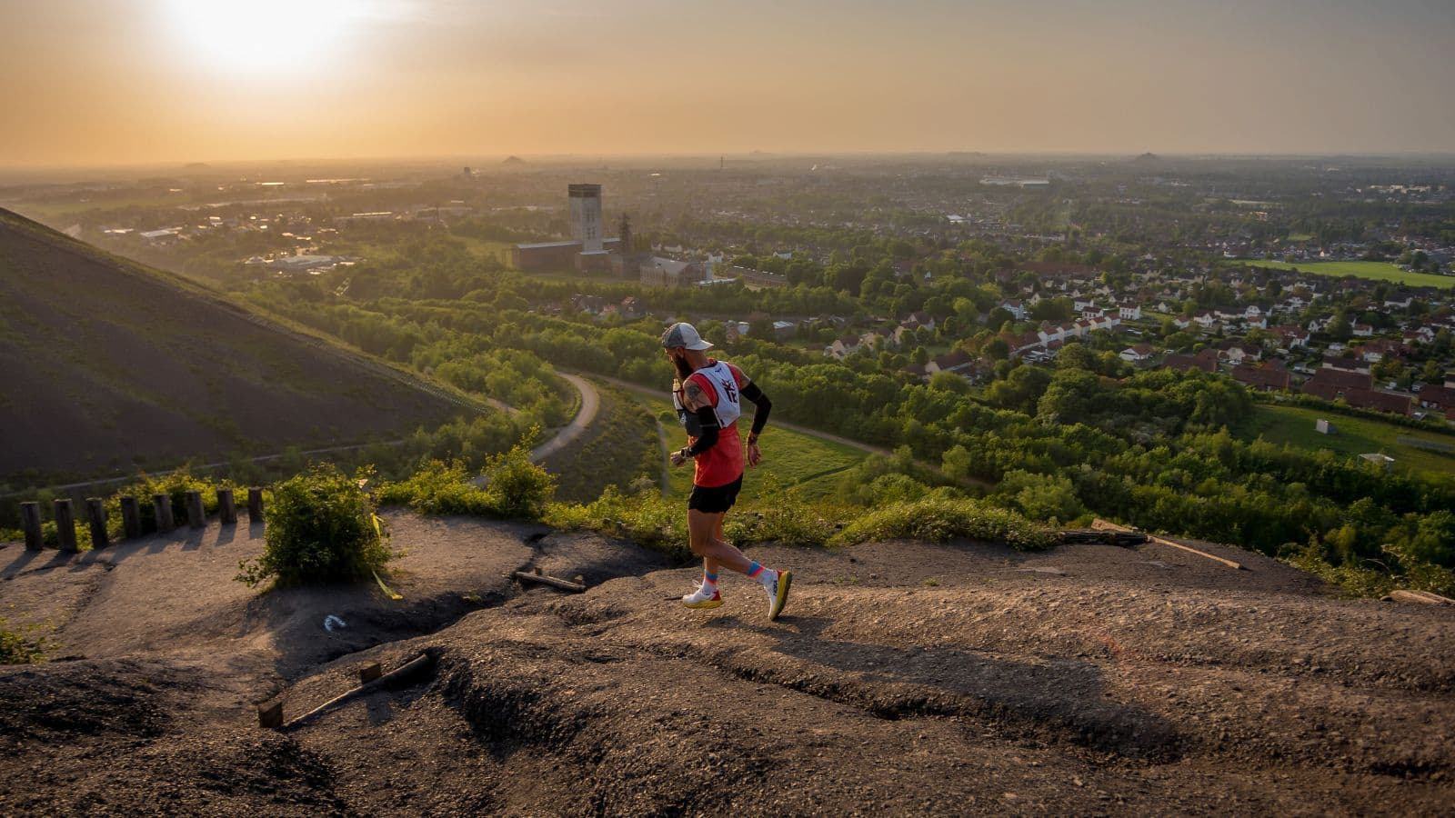 trail runner climbing steep hill while maintaining efficient running form during hill repeats