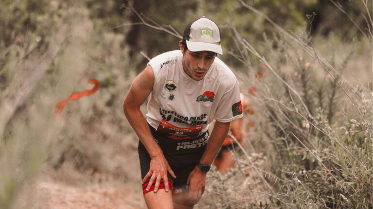 trail runner experiencing tight calf muscles while running on technical mountain trail