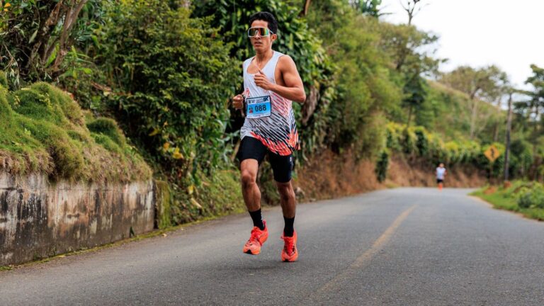 Triathlete walking on a trail during an active recovery session to reduce muscle soreness after downhill running.