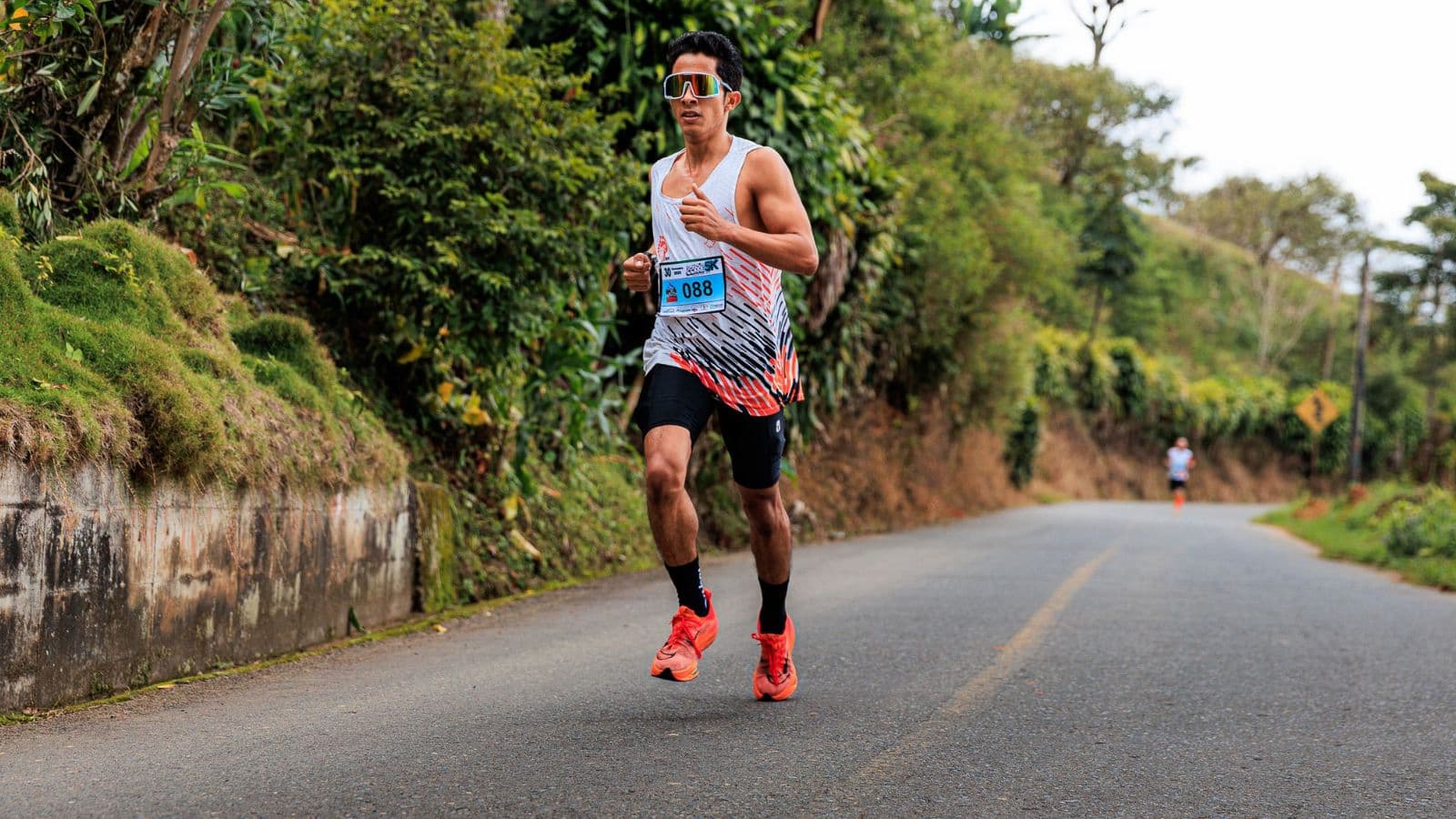 Triathlete walking on a trail during an active recovery session to reduce muscle soreness after downhill running.
