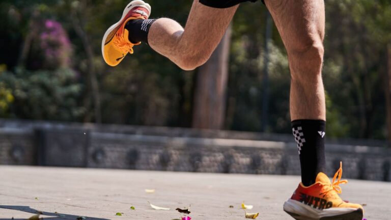 trail runner stretching tight leg muscles before mountain run to improve performance and mobility