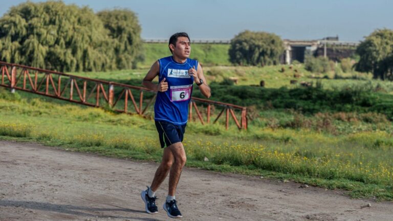 Trail runner walking beyond the finish line after a downhill trail race to promote active recovery and reduce post-race muscle soreness.