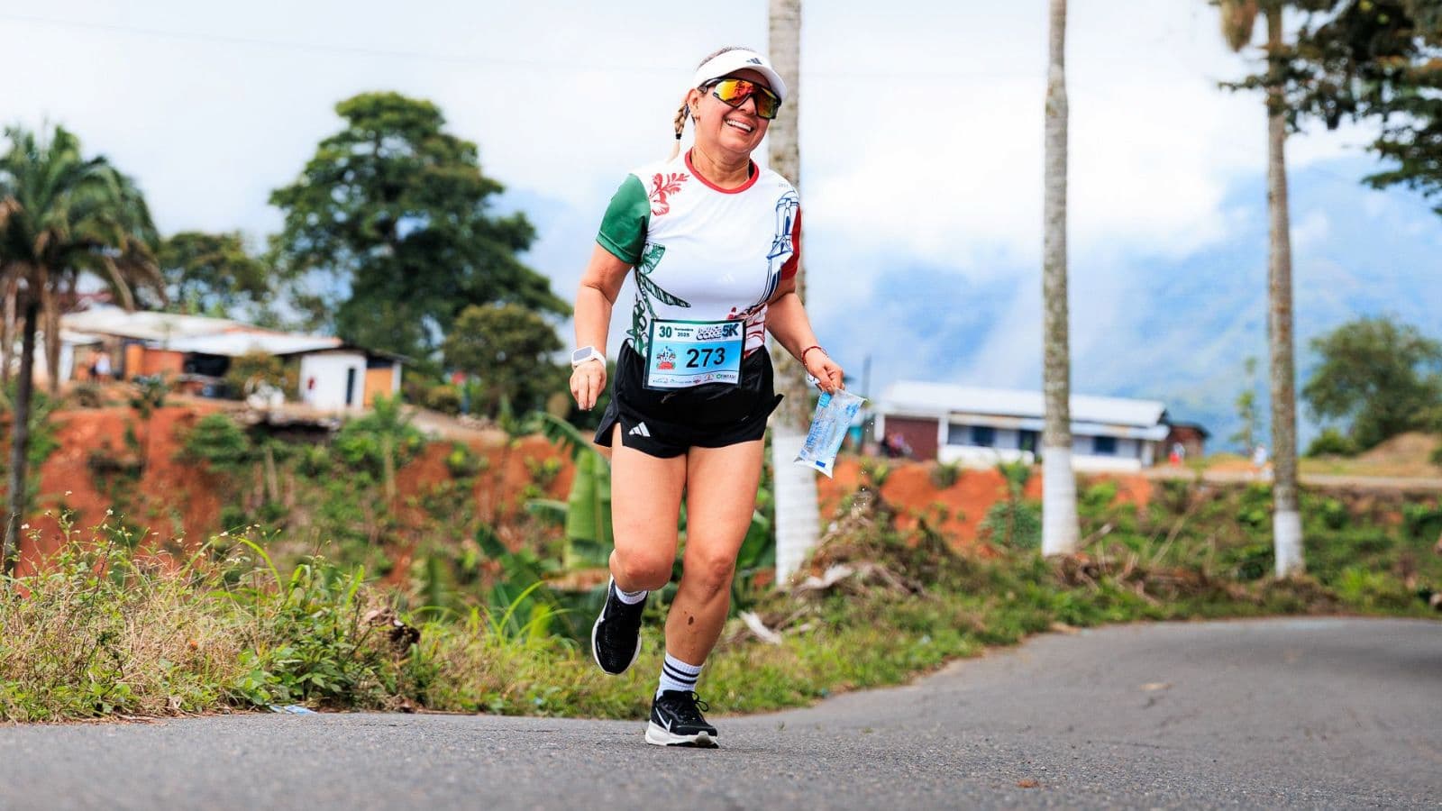 Trail runner pausing on a mountain trail to enjoy a scenic view during an outdoor running session.