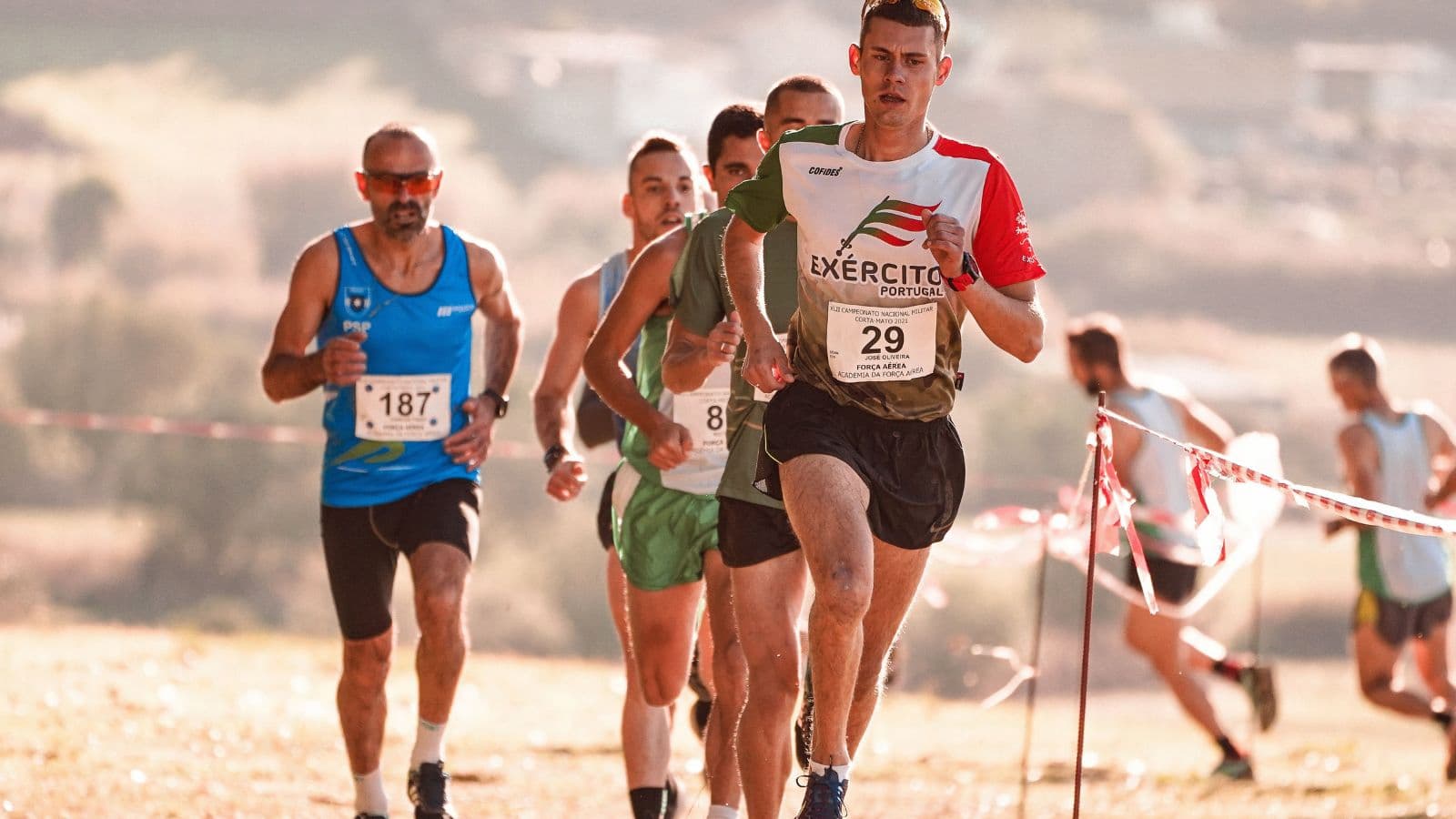 Trail runners completing uphill repeat intervals to improve leg strength, power, and running speed for trail races.