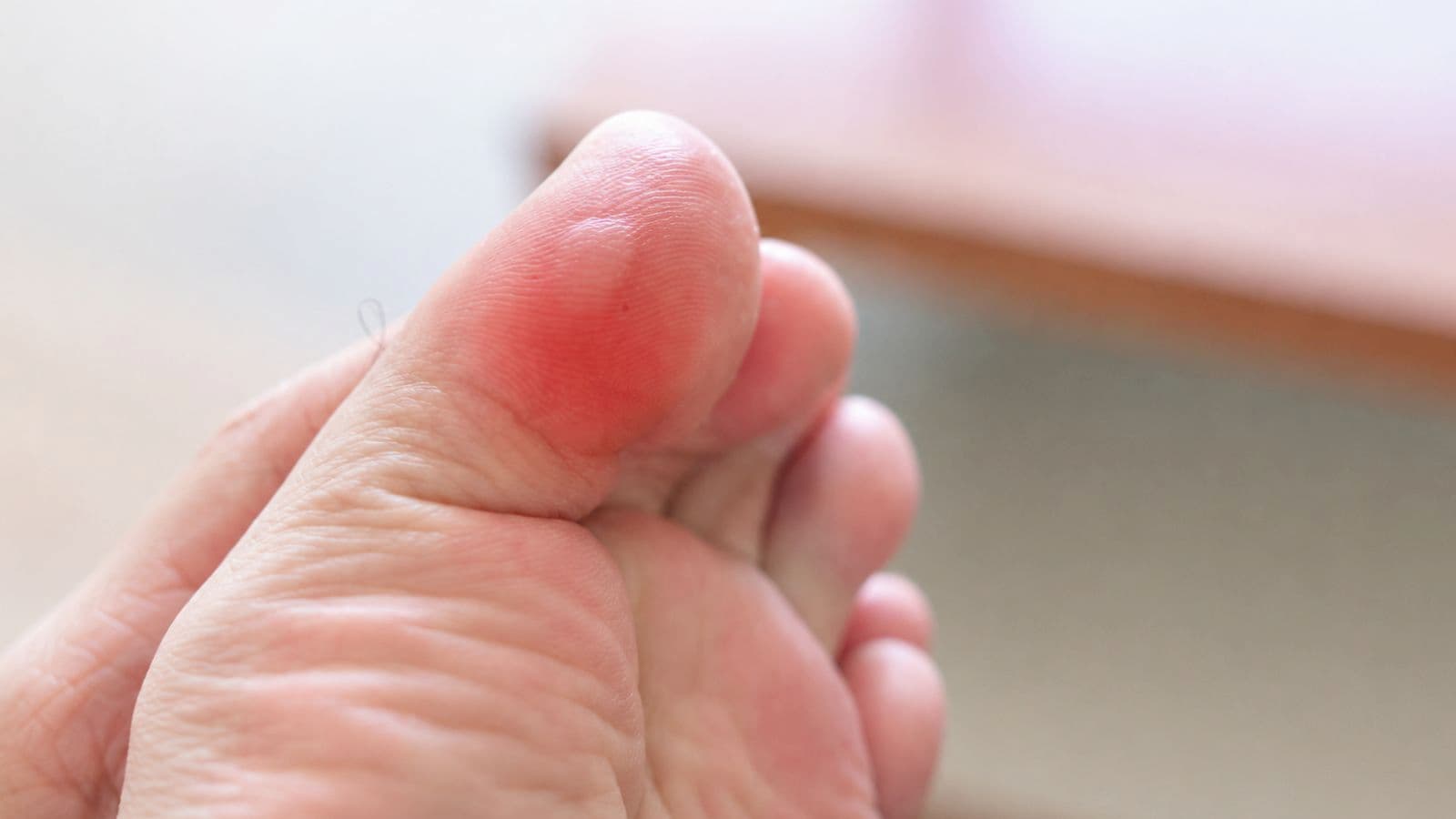 trail runner checking running shoe after developing blister from technical trail conditions