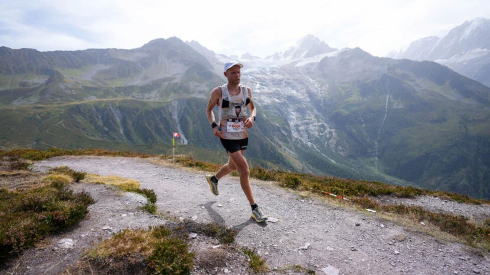 Trail runner maintaining balance while running across rocky and uneven terrain on a technical mountain trail.