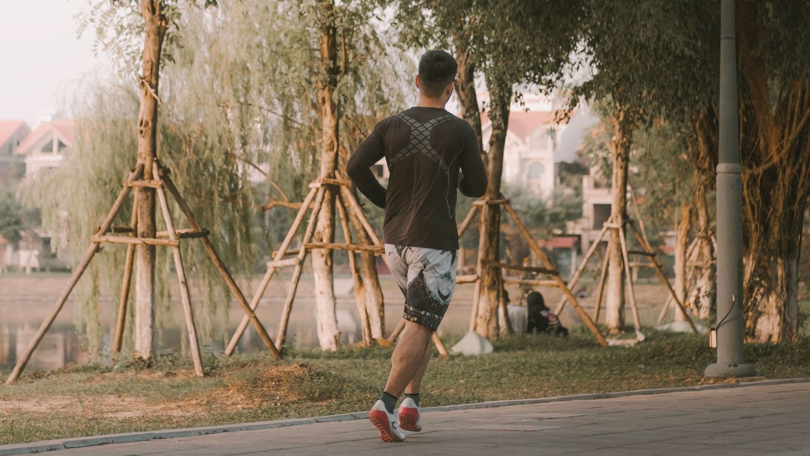 Trail runner maintaining an upright posture with a relaxed upper body while running on a technical forest trail.