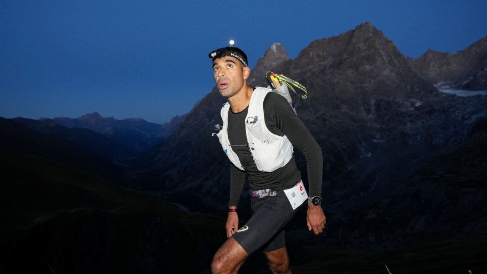 Trail runner looking ahead and choosing a stable foot placement while navigating rocks and tree roots on a technical trail.