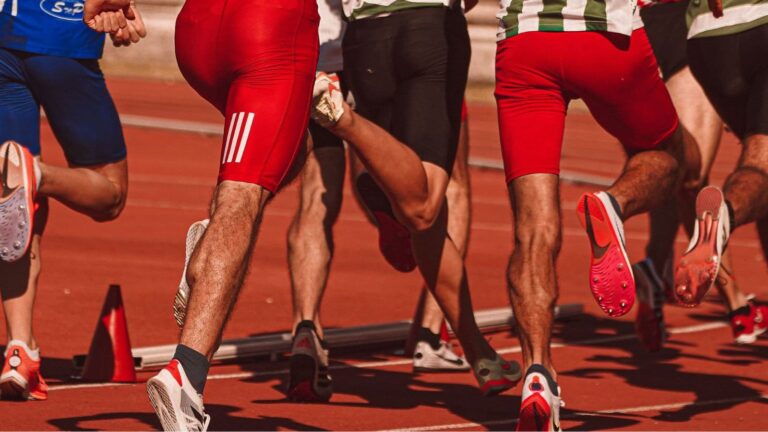 Runner checking weekly mileage on a GPS watch after increasing running volume too quickly during training.