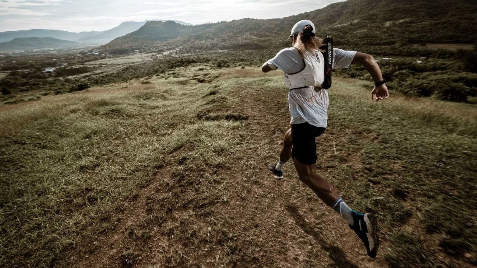 Trail runner maintaining a controlled effort while climbing a steep hill during a challenging trail race.