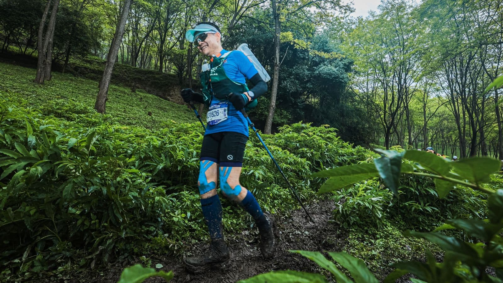 Trail runner moving at a controlled easy pace while climbing a long hill during an endurance training run.