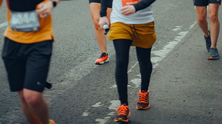 Runner checking a sports watch to follow planned running and walking intervals during a Jeffing workout.