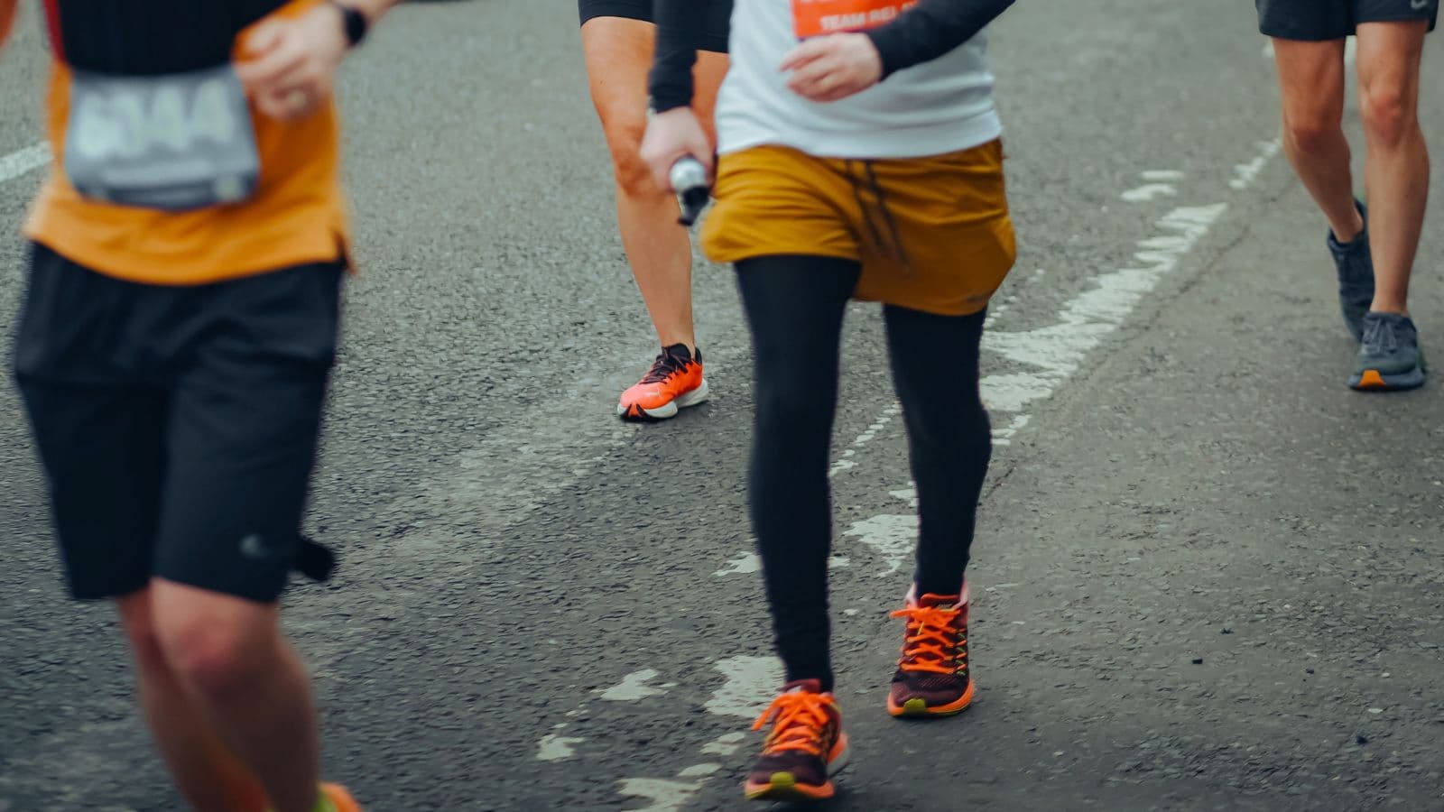 Runner checking a sports watch to follow planned running and walking intervals during a Jeffing workout.