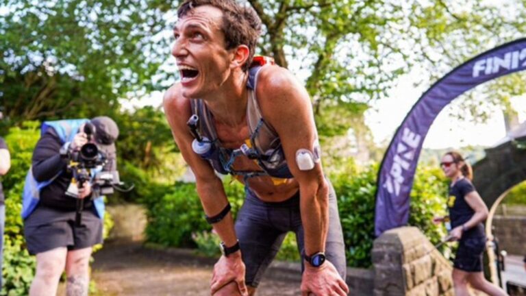 Exhausted distance runner slowing dramatically during a long race after running low on stored muscle glycogen.