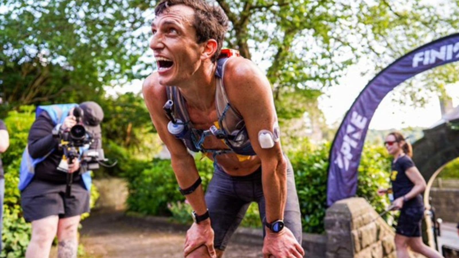 Exhausted distance runner slowing dramatically during a long race after running low on stored muscle glycogen.