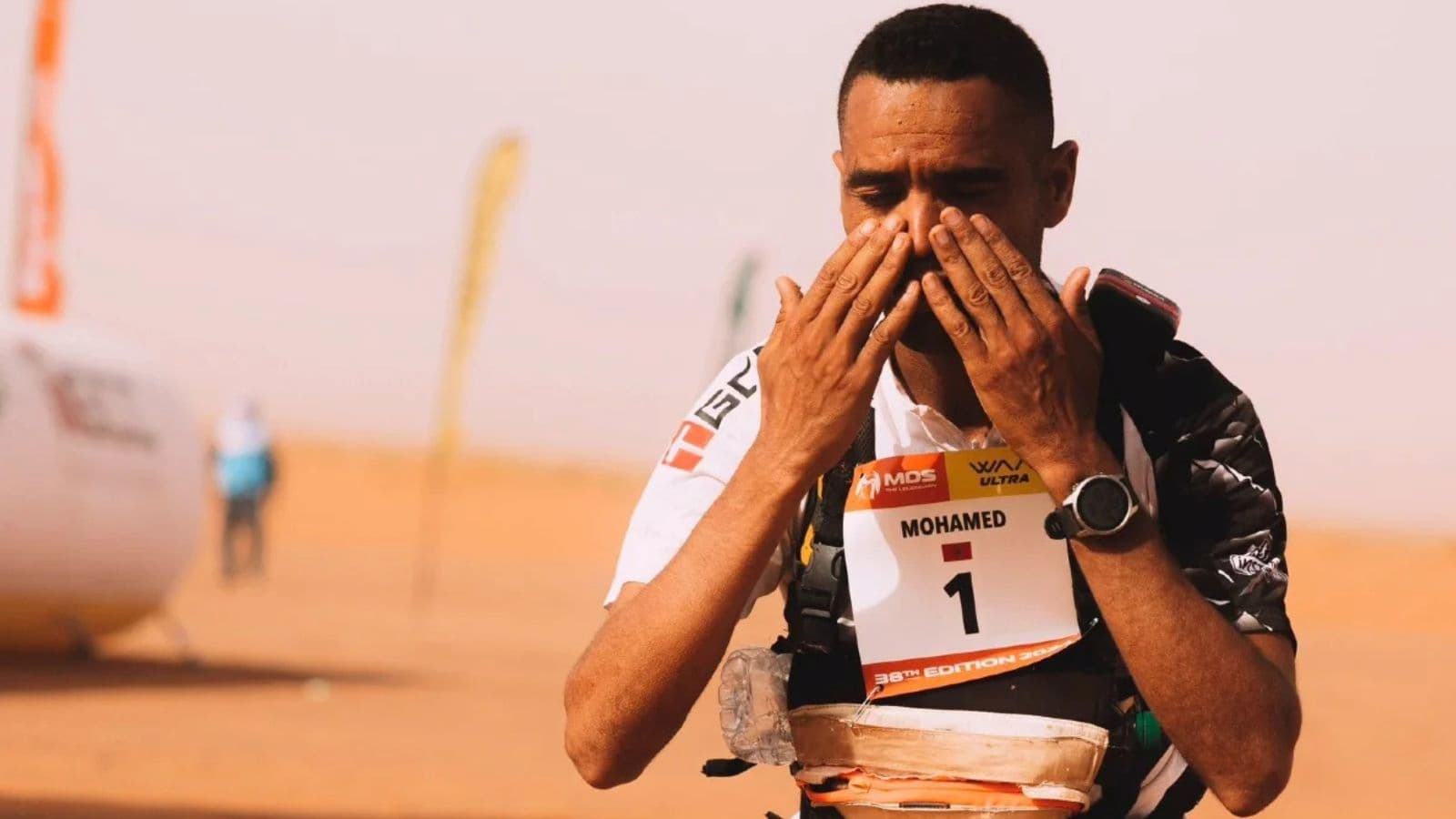 Trail runner maintaining focus while climbing a steep mountain trail during a physically demanding long-distance run.