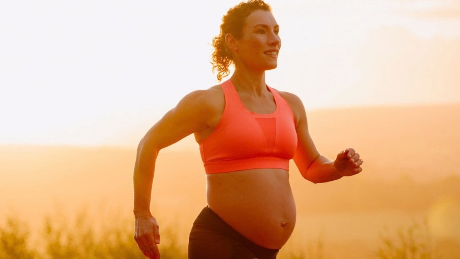 Pregnant runner completing an easy run at a controlled conversational effort instead of a demanding high-intensity workout.