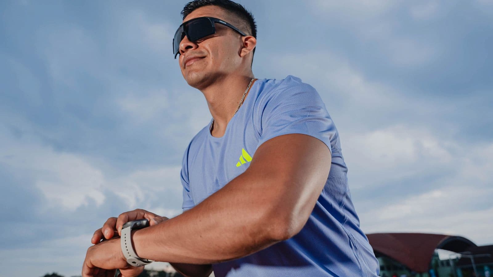 Runner checking real-time running power data on a sports watch during an outdoor training session.