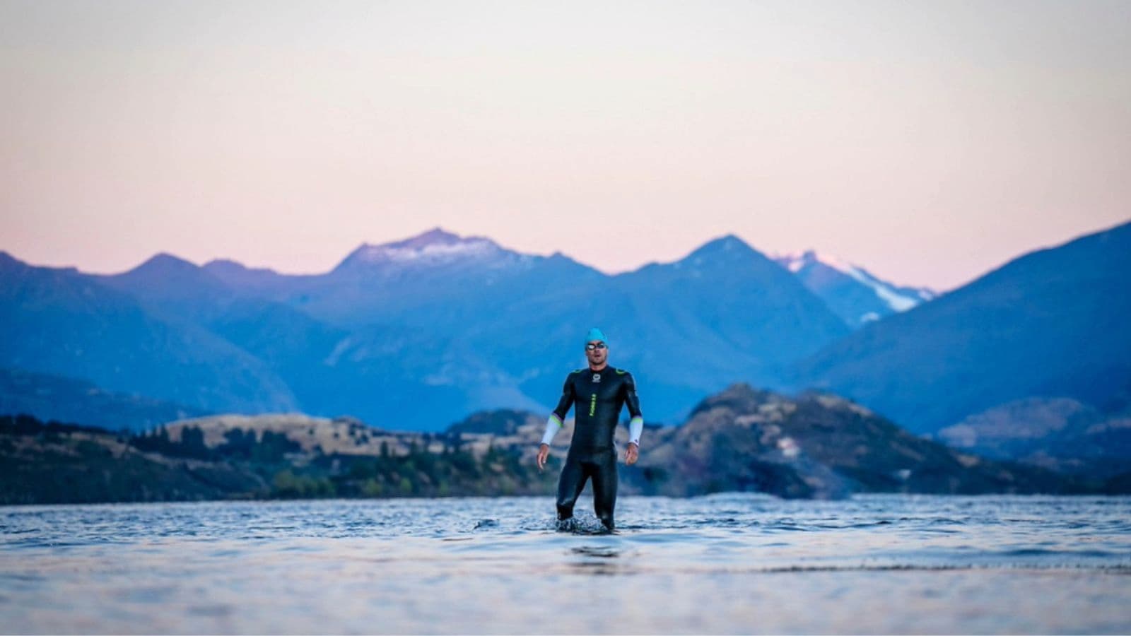 Distance runner completing steady freestyle laps in a swimming pool to develop cardiovascular endurance.