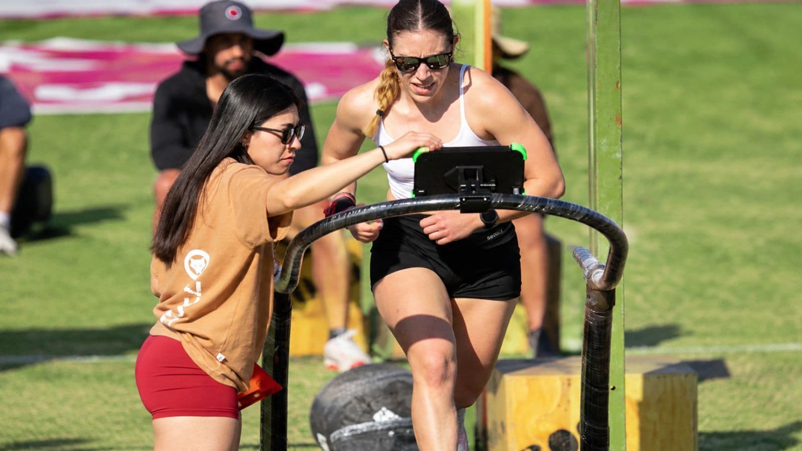 Running coach observing an athlete's stride, posture, and foot placement during a track workout to identify opportunities for technique improvement.