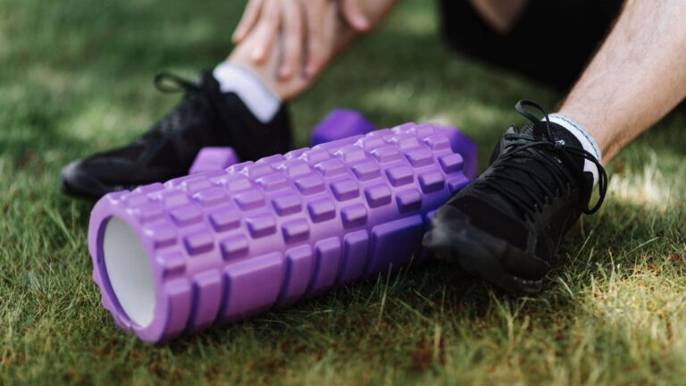 Runner using a foam roller on tight quadriceps muscles after a running workout to help reduce discomfort and improve mobility.
