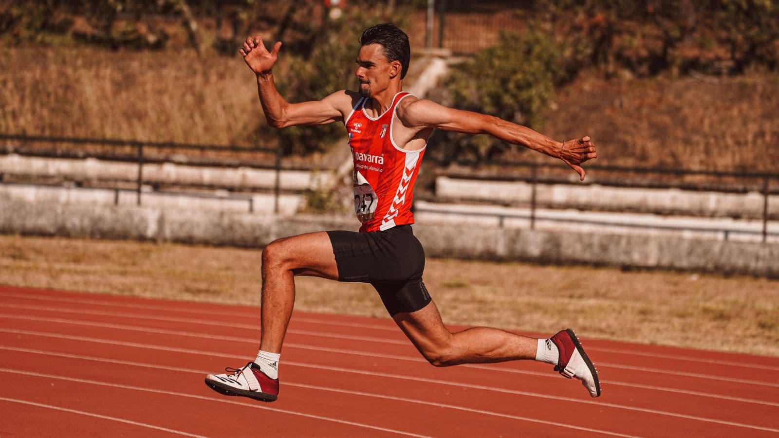 Experienced distance runner completing repeated controlled running intervals with short jogging recoveries during a structured track workout.