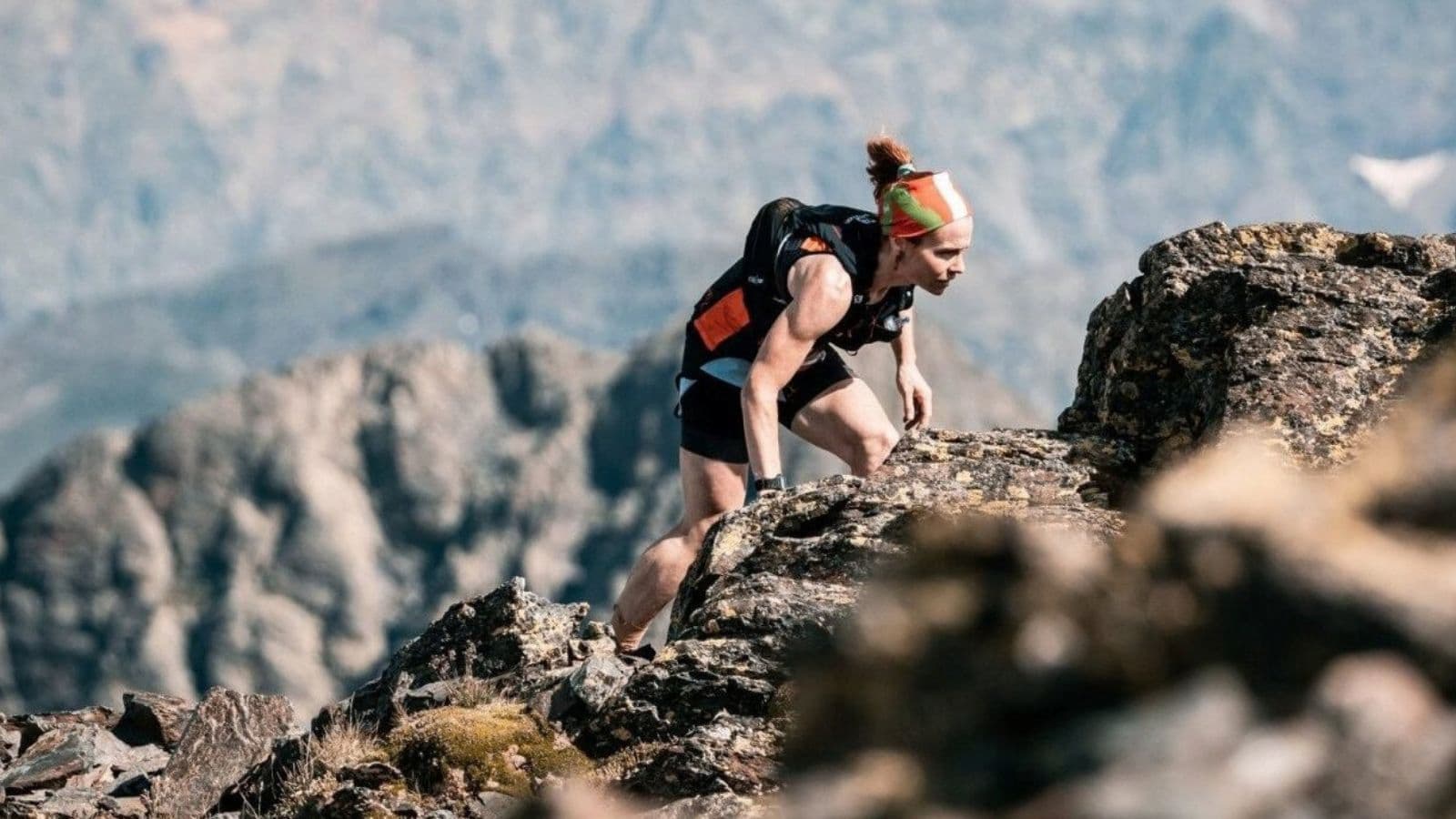Trail runner carefully navigating a rocky downhill section while practicing balance, foot placement, and controlled descending technique.