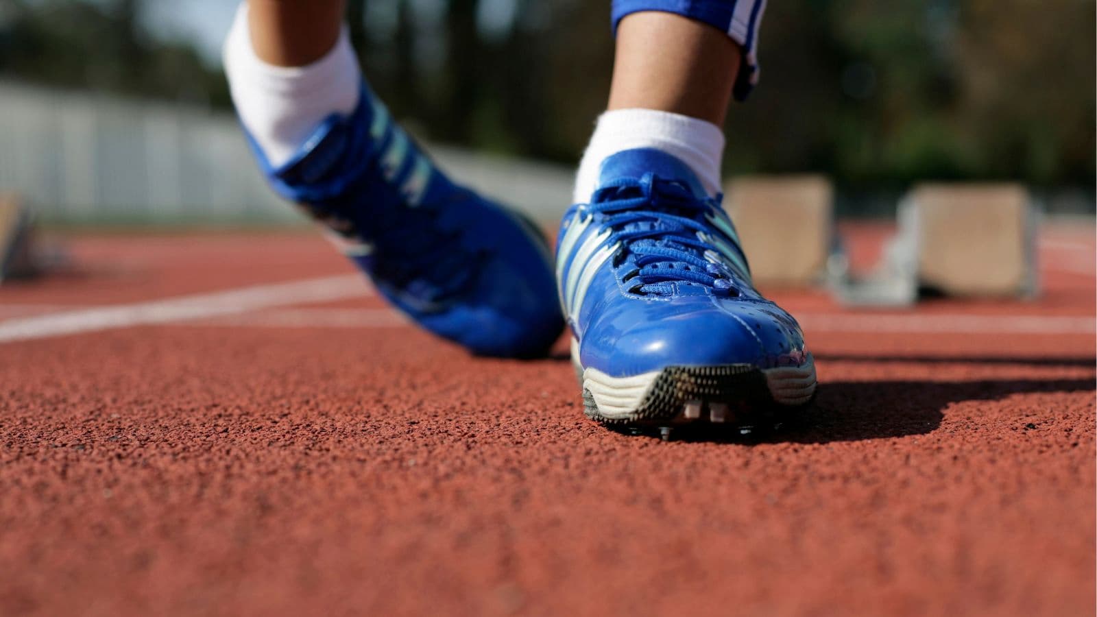 Trail runner sitting beside a woodland path after sustaining a fall due to twisting of ankle